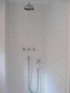 哥本哈根ApartmentInCopenhagen Apartment 17的白色瓷砖浴室内的淋浴