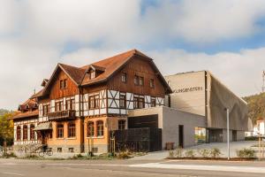 布劳施泰因Klingenstein AKZENT Hotel Wirtshaus Brauerei的一座大型木制建筑,毗邻一座建筑