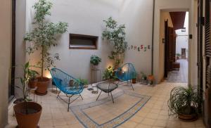 布宜诺斯艾利斯拉德莱赛精品酒店的走廊上种有植物,配有两把椅子和一张桌子