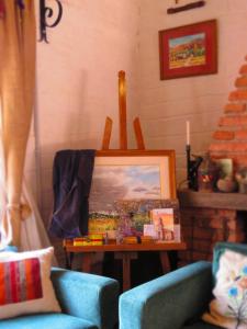 麦马拉La Paleta del Pintor Hosteria的客厅配有两把椅子和一张带绘画的桌子