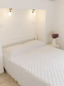 普利莫顿Rooms的白色卧室配有带白色床单的床