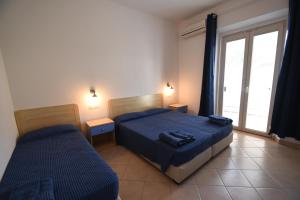 坎波内莱尔巴Hotel la Conchiglia的一间卧室设有两张床和窗户。