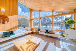 白马村Hakuba Amber Resort by Jade Group的带沙发和窗户的大型客厅