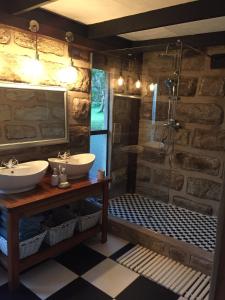 焦济尼Cycad Rock Fishing Lodge的一间带两个盥洗盆和淋浴的浴室
