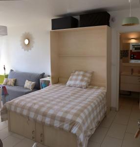 圣让-德蒙Studio Front de Mer的一间卧室配有一张床和一张沙发