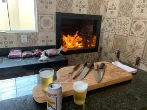 大坎普Espaço Laranjeira的配有两杯啤酒和壁炉的切板