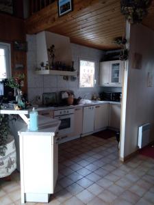 绍尔日Greselin的一间厨房,配有白色家电和木制天花板