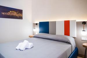 切法卢Incao Holiday Giudecca House的一间卧室配有一张床,上面有两条毛巾
