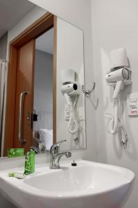 伊塔蒂亚亚GRAAL INN ITATIAIA的浴室水槽配有2个吹风机和镜子