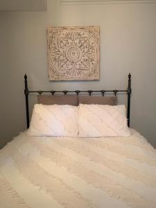 芝加哥Penthouse Level, Stunning Wrigley Stay的一张带白色枕头的床和一张墙上的照片
