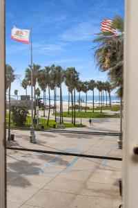 洛杉矶萨摩逊威尼斯海滩旅馆的享有棕榈树海滩和美洲旗的景致。