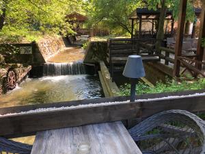 弗尔尼亚奇卡矿泉镇Garni hotel Vir的瀑布前的木凳