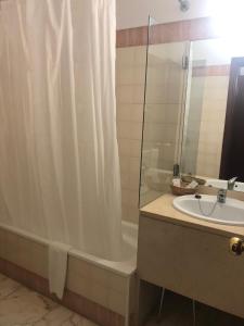 维迪堡卡斯特罗德韦德酒店的浴室配有淋浴帘、浴缸和盥洗盆。