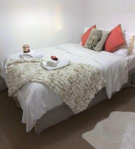 布莱顿霍夫Charming Cottage & Garden - central Brighton!的一间卧室配有一张带白色毯子和枕头的床。