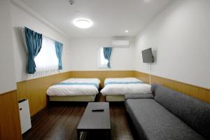 北谷町Phoenix Ryukyu Henzanbaru -SEVEN Hotels and Resorts-的一间带两张床和一张沙发的客厅