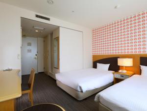 苫小牧市苫小牧永安国际酒店的酒店客房,配有两张床和椅子