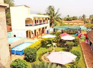 KpaliméHotel Ganiela的享有带游泳池和遮阳伞的度假村的空中景致