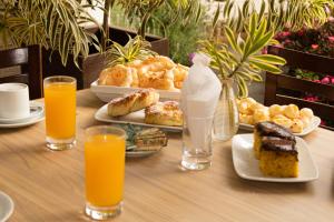 卡尚布Pousada Golden Garden的餐桌上放有食物和橙汁