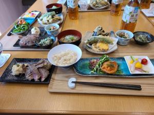 秦野市Business Hotel Takanoya的一张木桌,上面放着食物盘