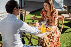 马托西纽什MyStay Matosinhos Centro的坐在餐桌旁吃食物的男人和女人