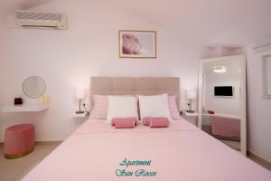 西尼卡Apartment San Rocco的卧室配有一张带两个粉红色枕头的大型白色床。