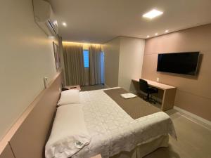 乌贝兰迪亚马拉若酒店的配有一张床和一张书桌的酒店客房