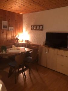 芙露姆赛山Casa Alpetta的客厅配有桌子和电视