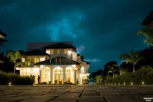 马特莱Lakegala Resort的一间白色的大房子,晚上有灯光