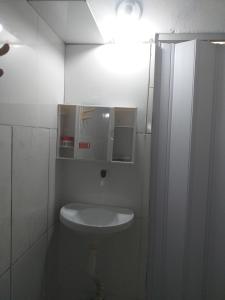 甘博阿Casa em Gamboa的白色的浴室设有卫生间和灯