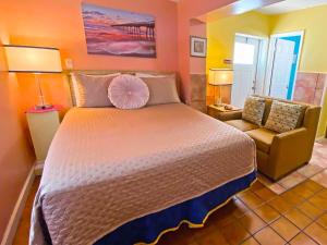 圣徒皮特海滩Bella Sirena Inn的一间卧室配有一张大床和一把椅子