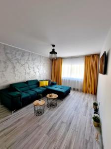 锡比乌Apartament Central Iulia的客厅配有绿色沙发和2张桌子