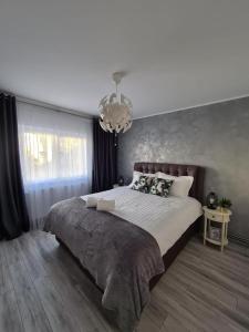 锡比乌Apartament Central Iulia的一间卧室配有一张大床和一个吊灯。