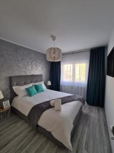 锡比乌Apartament Central Iulia的一间卧室配有一张带蓝色窗帘的大床