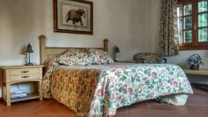 索托德尔雷亚尔La Casita de Chozas的一间卧室配有一张床和一个带床罩的床头柜