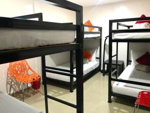 麦克坦HalfWay House Hostel Mactan Cebu Airport的带4张双层床和椅子的客房