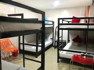 麦克坦HalfWay House Hostel Mactan Cebu Airport的带4张双层床和椅子的客房