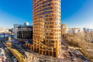基辅2к квартира у новому будинку на 10 поверсі, Печерськ的一座城市里高大的黄色建筑,有停车的汽车