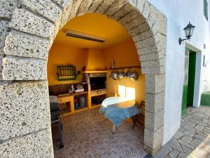 FasniaCasa Rural La Sombrera的一间厨房里的拱门,里面配有桌子