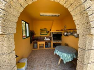 FasniaCasa Rural La Sombrera的一个带拱门的厨房和一张桌子