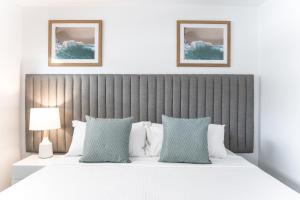 卡伦德拉伦巴海滩度假酒店的一间卧室配有一张带蓝白色枕头的大床
