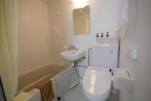 大町市黑部观光酒店的白色的浴室设有卫生间和水槽。