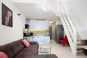 西尼卡Apartment "Santa Lucia"的一间带棕色沙发的客厅和一间厨房