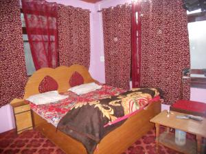 斯利那加Alamdar guest house的一间卧室配有一张带红色窗帘的木床