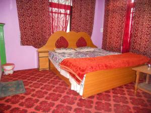 斯利那加Alamdar guest house的一间卧室配有一张红色棉被的床