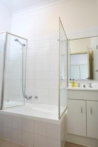 墨尔本索非亚酒店的白色的浴室设有浴缸和水槽。