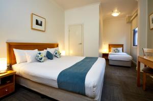 墨尔本索非亚酒店的酒店客房设有一张大床和一张书桌。