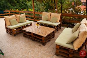 Gornja TrepčaGuesthouse Edelnice的庭院设有两把椅子和一张带枕头的木桌。