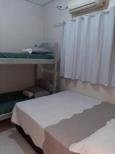 卡罗莱纳Casa de dois quartos的一间卧室设有两张双层床和一扇窗户。