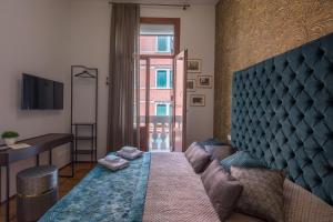 威尼斯B&B Cà del Poeta的一间卧室配有一张床、一张书桌和一个窗户。