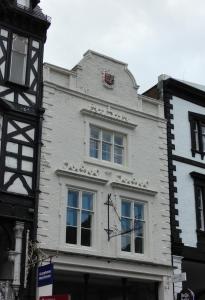 切斯特Eastgate Hideaway - central, luxury apartment on Chester's historic rows的白色的建筑,旁边有一个钟
